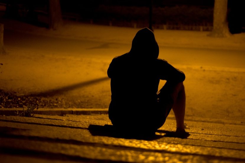 ausgebrannt, burnout bei Jugendlichen. Jugendlicher sitzt alleine nachts auf der Strasse